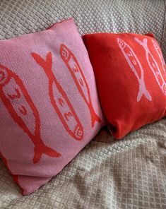 two red pillows sitting on top of a bed