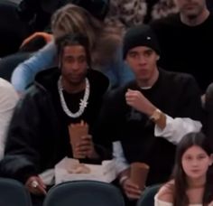 two people sitting next to each other at a basketball game