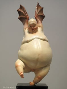 a figurine of a flying creature on a black base