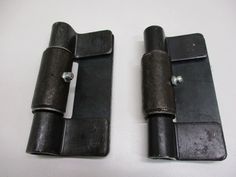 two black metal door hinges on a white surface