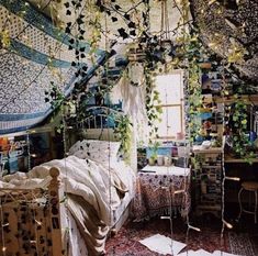 a bed room with a neatly made bed and lots of plants hanging from the ceiling