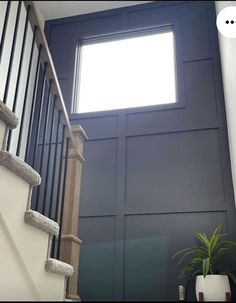 stairs leading up to an open window in a house with blue walls and white railings