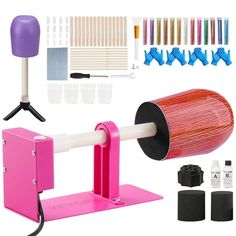 an assortment of crafting supplies including a pink machine and other items on a white background