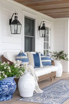 the porch is decorated with blue and white pillows, potted plants, and lanterns