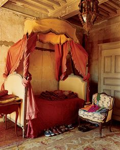 an old bedroom with a canopy bed and chair