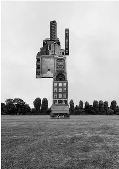 a black and white photo of a building made out of buildings in the middle of a field