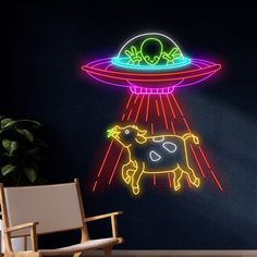 an image of a neon sign with a cow in the center and a flying saucer above it