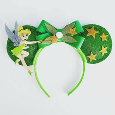 a green mouse ears with tinkerbells on top and stars around the ears