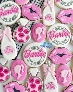 decorated cookies with pink and white icing are on a cooling rack, next to each other