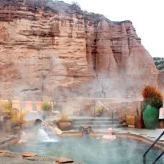 hot springs with people in them near some mountains