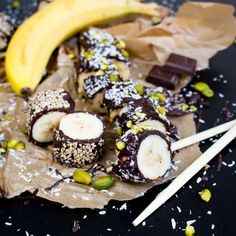 chocolate covered bananas and pistachios on top of brown paper