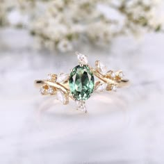 a ring with an oval green stone surrounded by white flowers