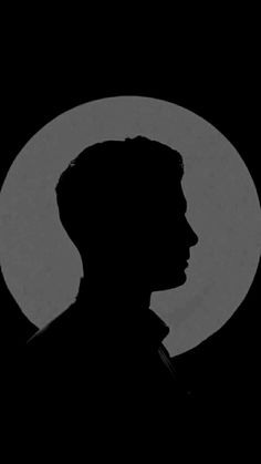 the silhouette of a man in front of a full moon with his head turned to the side