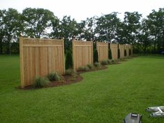 a row of wooden fences sitting on top of a lush green field