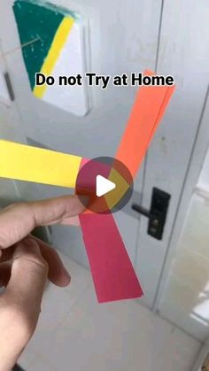 someone is holding some colored paper in front of a door with the words do not try at home