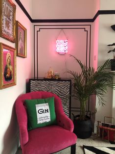 a pink chair sitting in front of a neon sign