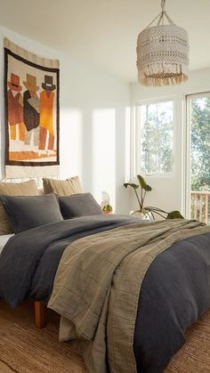 a bedroom with a bed, rugs and pictures hanging on the wall above it