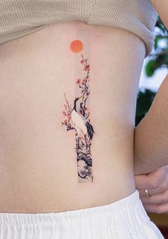 a woman's lower back tattoo with birds and flowers