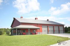 a large red barn sitting on top of a lush green field