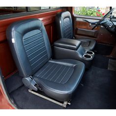 the interior of an old car with black leather seats and chrome trim, including steering wheel