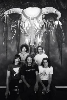 an old black and white photo of five people posing for a picture in front of a painting