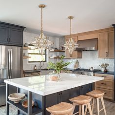 a kitchen island with three stools in front of it