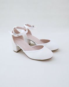 a pair of women's white shoes sitting on top of each other