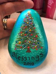 a painted rock with a christmas tree on it and the words blessing written in black