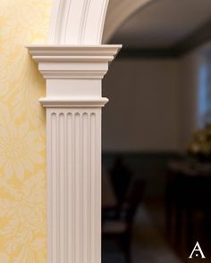 an arch in the corner of a room with yellow wallpaper