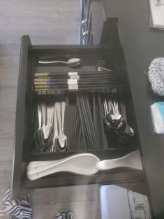 an organized drawer with utensils and other items