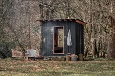 an outhouse in the woods with trees around it