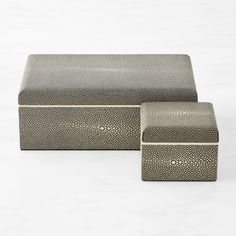 two silver boxes sitting next to each other on a white surface with no one in it