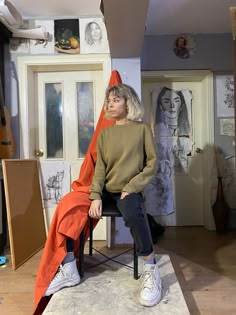 a woman sitting on top of a chair in a room