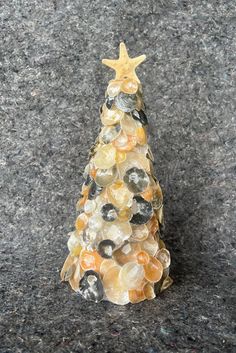 a christmas tree made out of rocks on top of a gray surface with a star