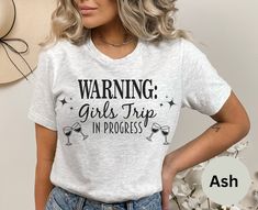 a woman wearing a t - shirt that says warning girls trip in progress on it