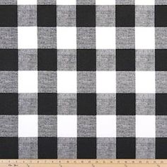 a black and white checkered fabric with a ruler in front of the plaid pattern