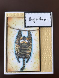 a card with an image of a cat hanging in there on it's side