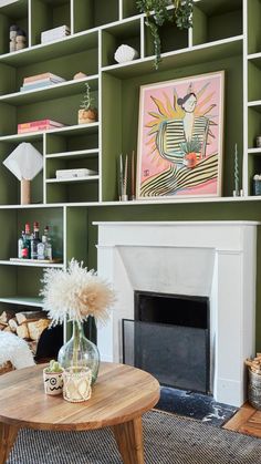 a living room filled with furniture and a fire place in front of a green wall