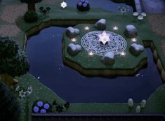 a small pond surrounded by trees and bushes with lights in the shape of a star