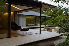 an outdoor living area with wooden flooring and stone walls