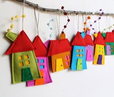 a group of colorful houses hanging from a tree branch with the words happy birthday in russian