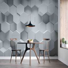 two chairs and a table in front of a wall with hexagonal tiles on it