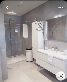 a modern bathroom with white fixtures and gray walls