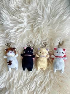 three crocheted key chains with cats on them