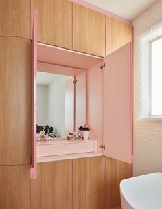 a bathroom with pink and white decor on the walls, sink and bathtub in it