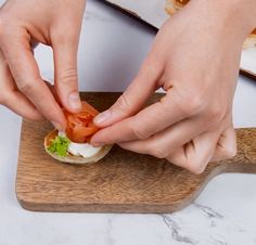 a person is preparing a sandwich on a cutting board