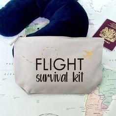 an airplane survival kit sits on top of a map with a blue pillow and passport