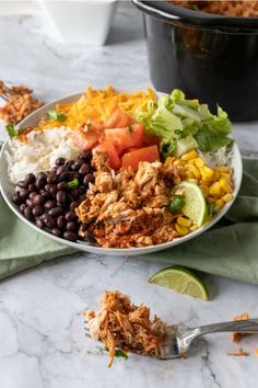 a white bowl filled with taco salad and black beans