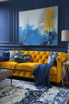 a living room with blue walls and yellow couches in the corner, along with a large painting on the wall