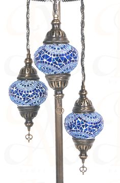 two blue and white mosaic glass lamps on a metal pole with chains hanging from it